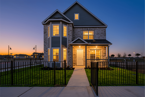 A house with a black fence and a walkway leading to the front door.