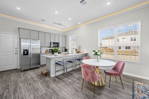 A kitchen with a table and chairs in front of a window.