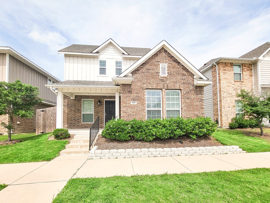 a brick house with a sidewalk in front of it