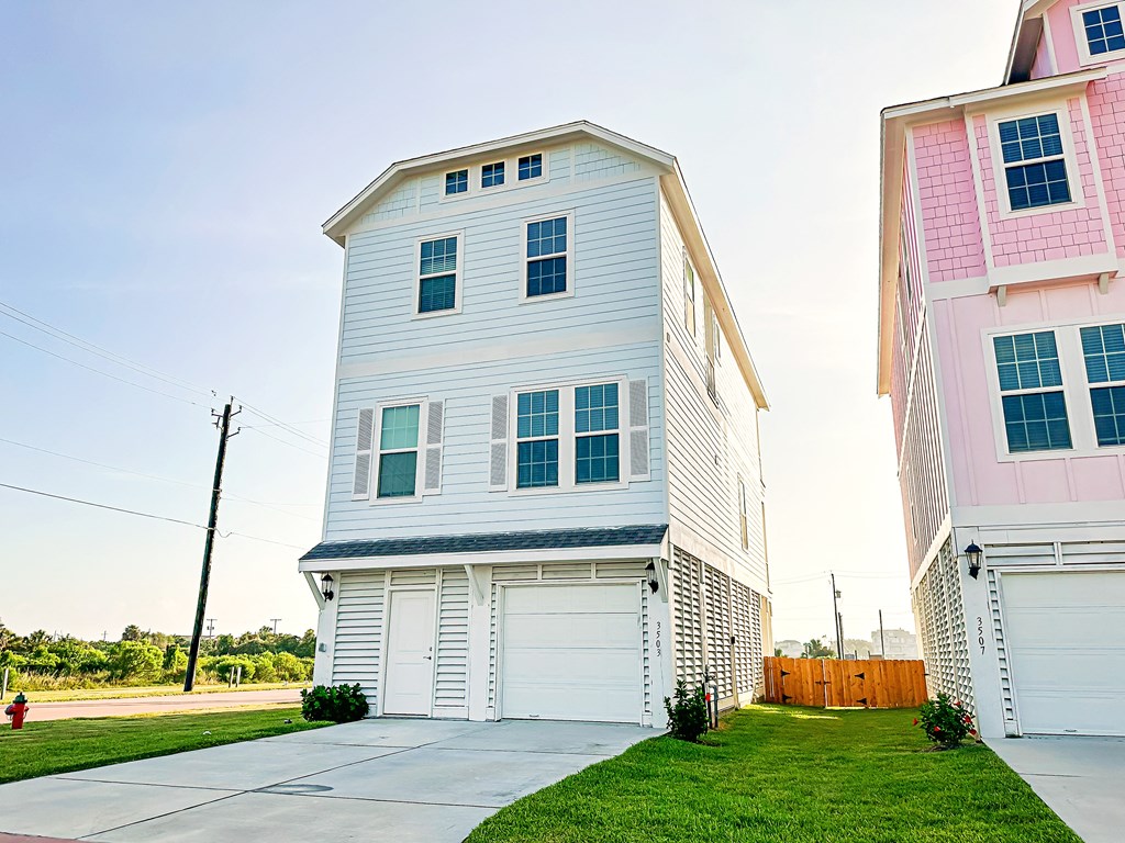 a white and pink house on the side of a street