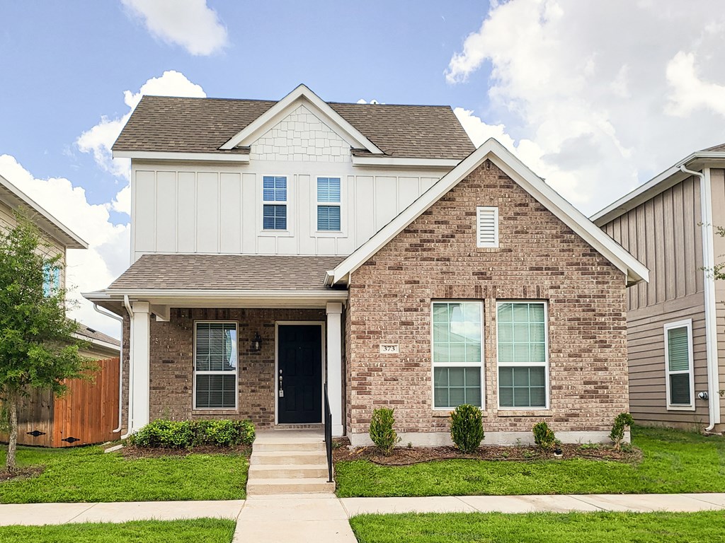 a brick and with a sidewalk and grass