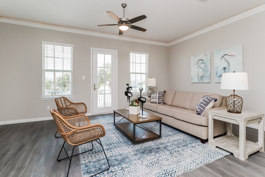 a living room with a couch and chairs and a ceiling fan