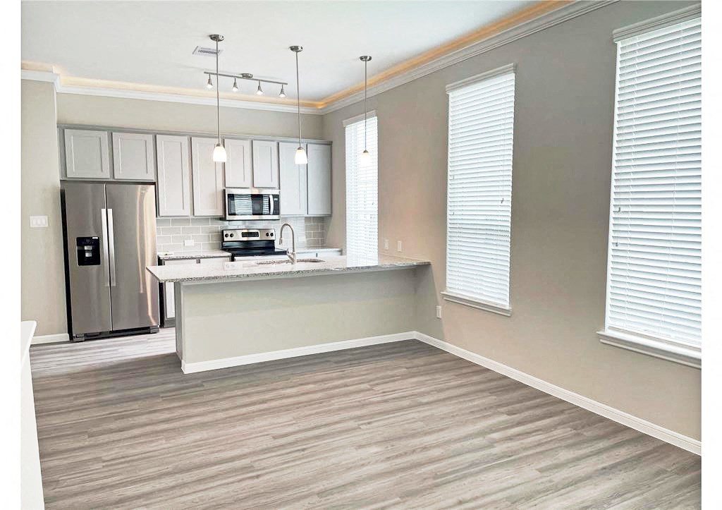 an empty kitchen with a sink and a refrigerator
