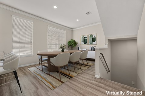 A dining room with a table and chairs.