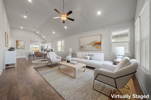 A living room with a white couch and a brown rug.