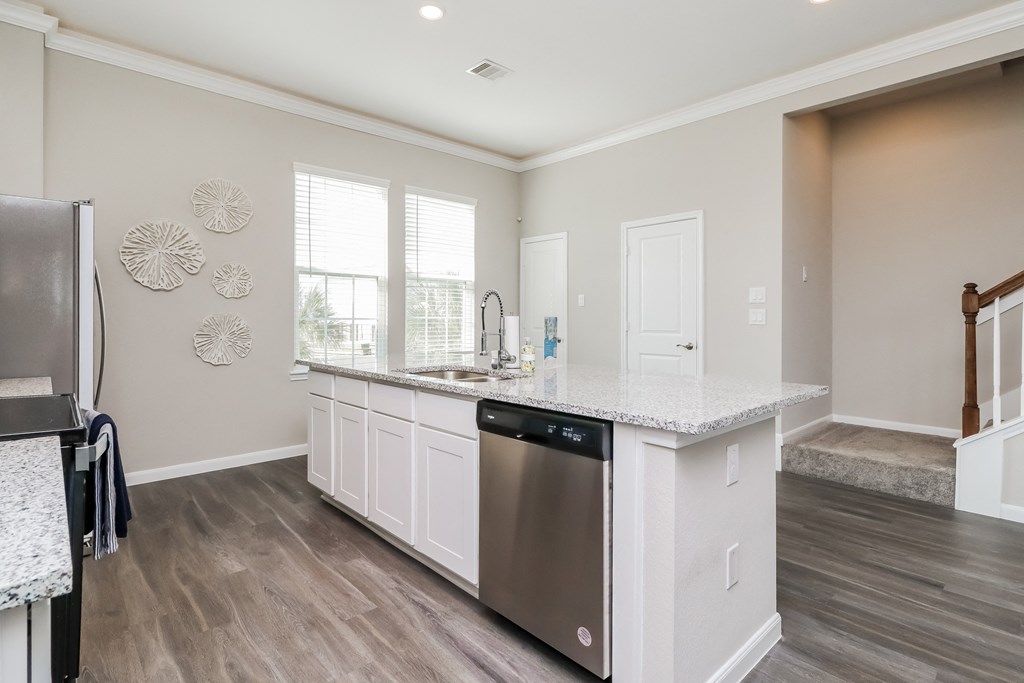 a kitchen with an island and a stainless steel dishwasher