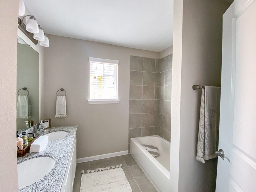 a bathroom with two sinks and a shower and a tub