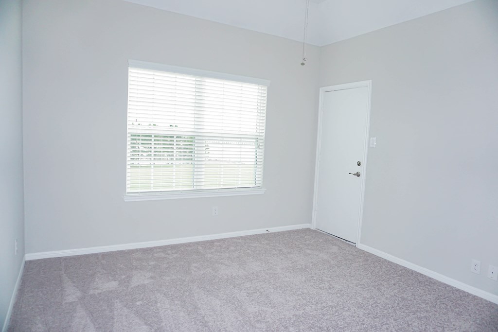 an empty room with a window and a door