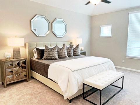 a bedroom with a bed and two mirrors on the wall