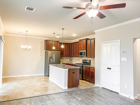 an empty kitchen with a ceiling fan