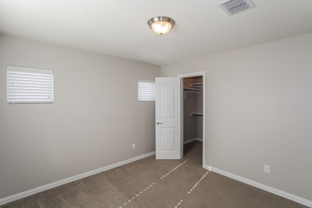 a bedroom with a closet and a door to a bathroom