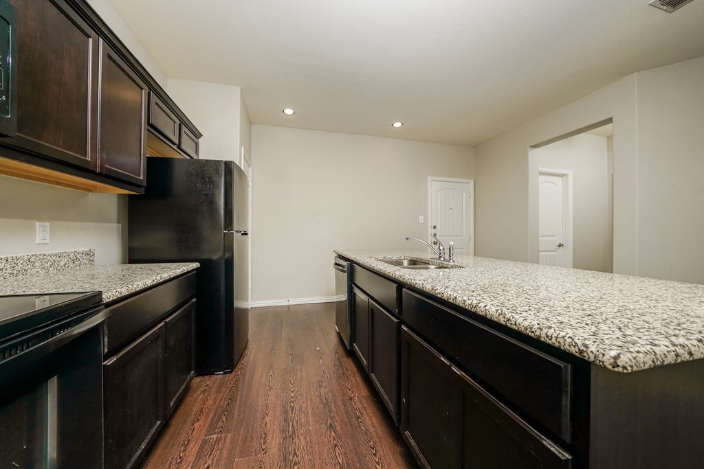 a kitchen with granite counter tops and black appliances