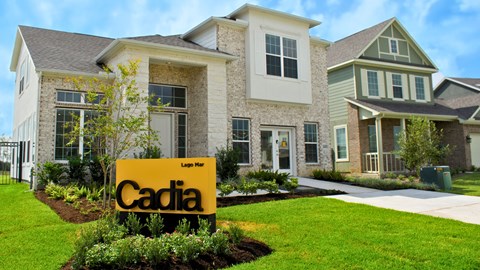 A yellow sign with the word Cadia in front of a house.