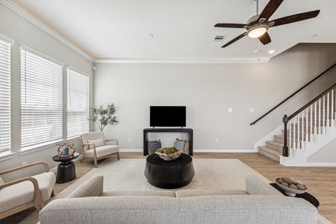 A living room with a grey couch and a black coffee table.