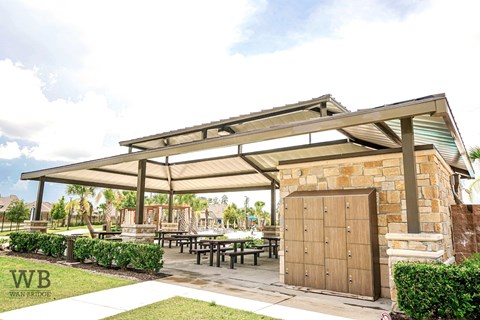 A covered patio area with tables and a wooden door.