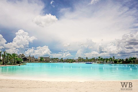 A beautiful beach with a clear blue sky and white clouds.