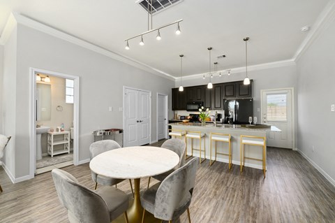 a dining room and kitchen with a table and chairs