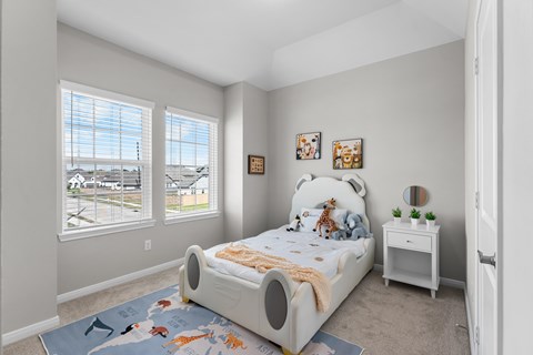 A bedroom with a large bed and a view of a parking lot through the window.