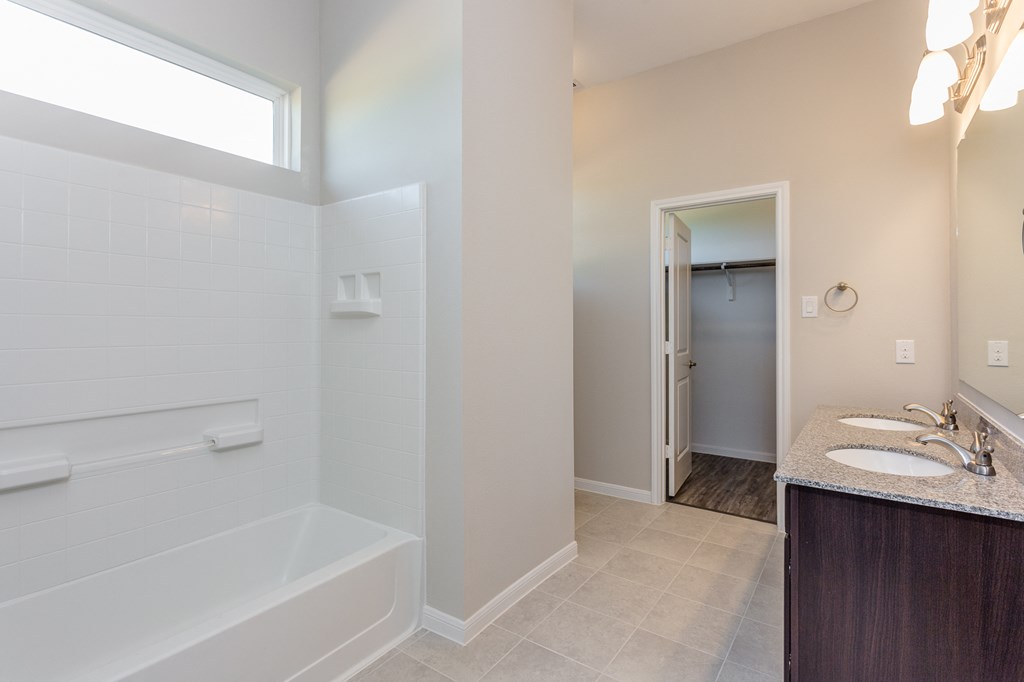 a bathroom with a tub and a sink and a mirror