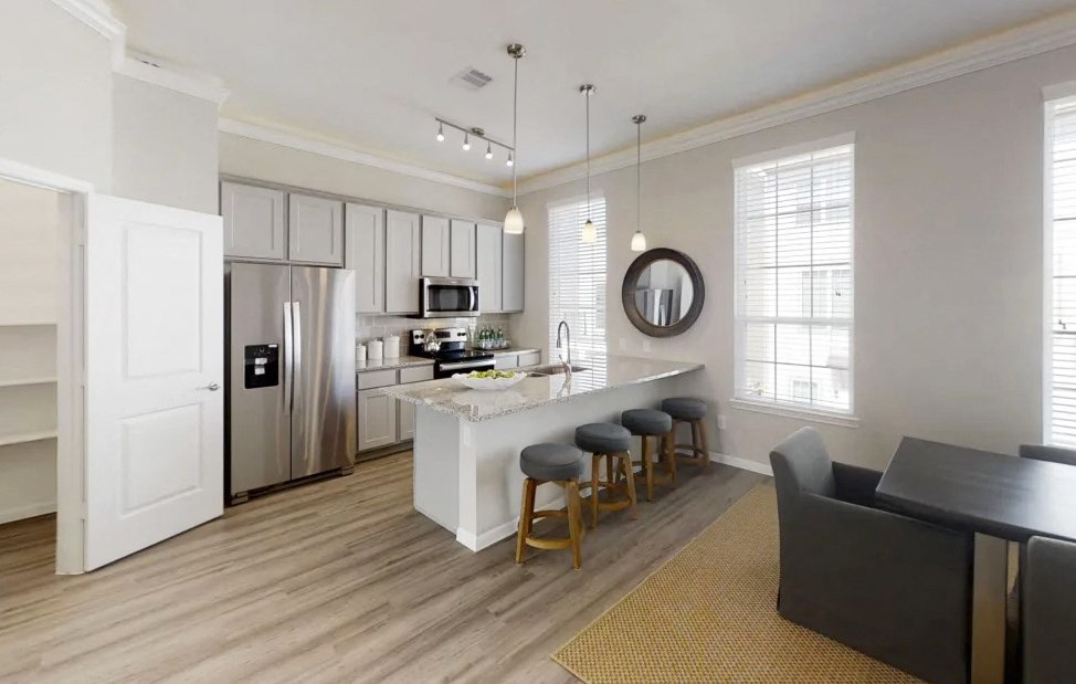 a kitchen and living room with an island and a refrigerator