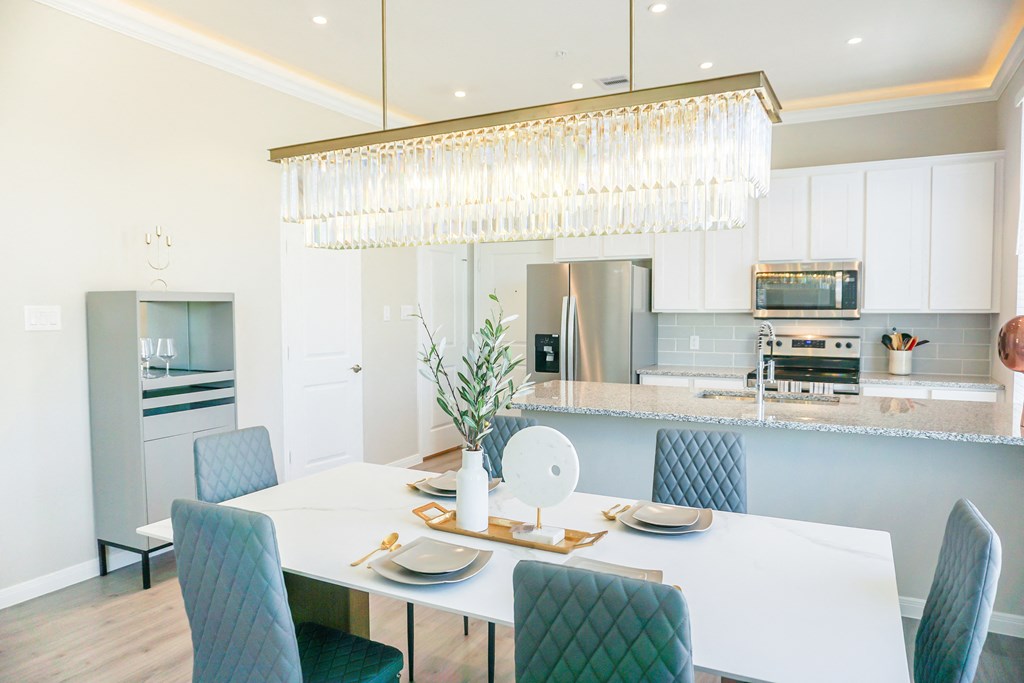 a dining room with a white table and blue chairs at Enclave at Mason Creek, Katy,TX