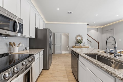 A kitchen with a stove top oven and a refrigerator.