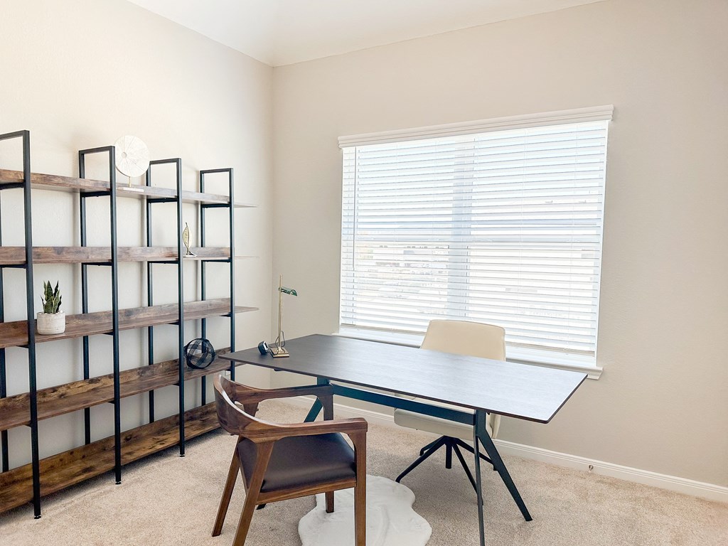 a desk and chair in a room with a large window and a bookshelf at Enclave at Mason Creek, Katy