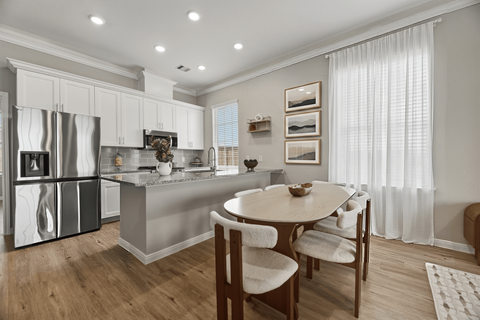 A modern kitchen with a dining table and chairs.