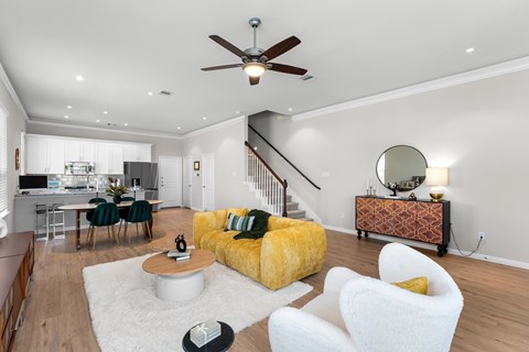 A living room with a yellow sofa and a white coffee table.