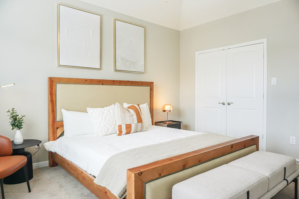 a bedroom with white walls and a bed with white and orange pillows at Enclave at Mason Creek, Katy,TX
