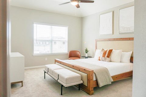 a bedroom with a bed and a chair and a ceiling fan