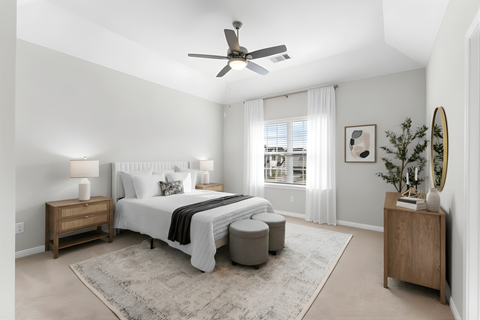 A bedroom with a bed, nightstand, and a ceiling fan.
