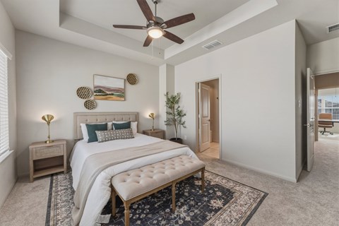 A bedroom with a large bed and a ceiling fan.