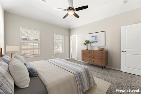 A bedroom with a bed, dresser, and window.