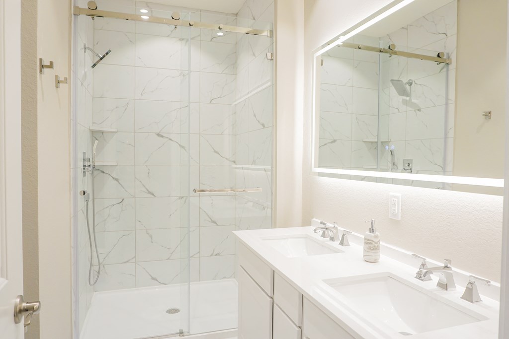 a bathroom with a shower and two sinks at Enclave at Mason Creek, Katy
