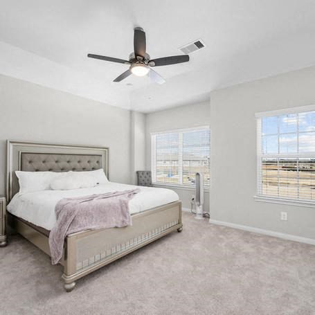 a bedroom with a bed and a ceiling fan