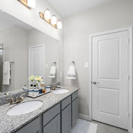a bathroom with two sinks and a large mirror