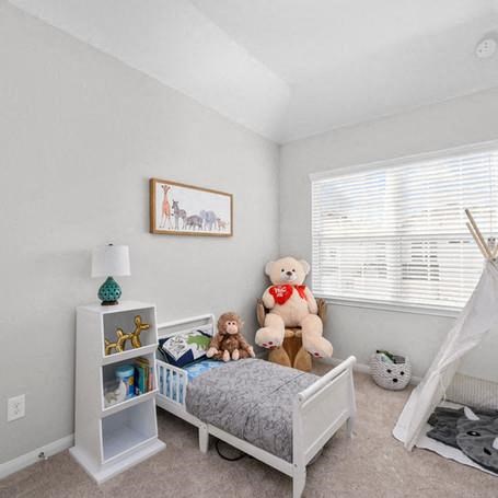 a bedroom with a bed and stuffed animals in it