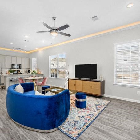 a living room with a blue couch and a ceiling fan