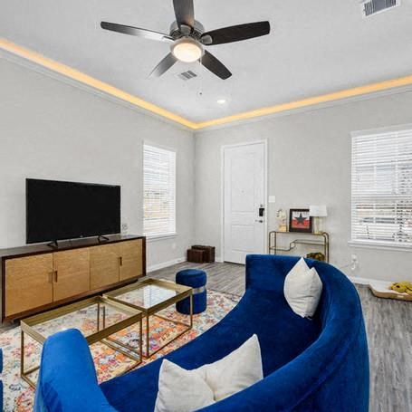 a living room with a blue couch and a ceiling fan
