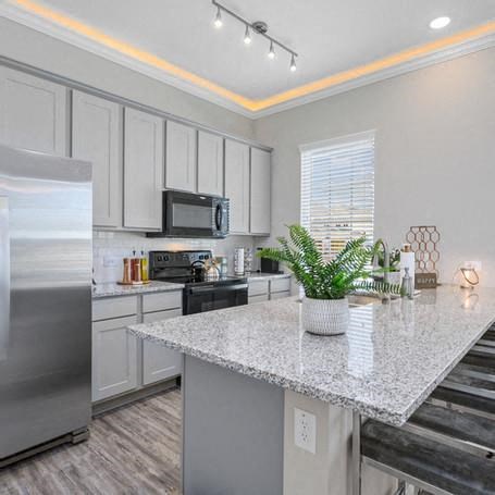 a kitchen with a granite counter top and a stainless steel refrigerator