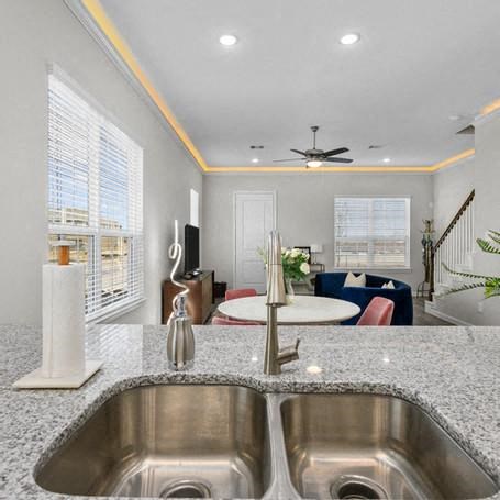 a kitchen with a sink and a view of a living room
