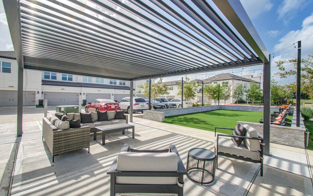 a patio with couches and tables and a large canopy at Enclave at Mason Creek, Katy