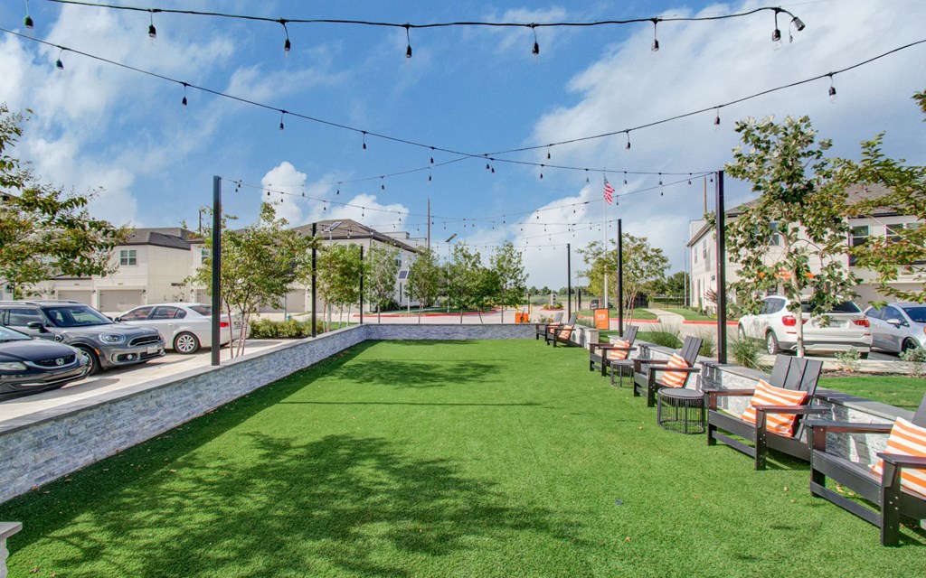 a yard with tables and chairs and a pool with grass at Enclave at Mason Creek, Katy