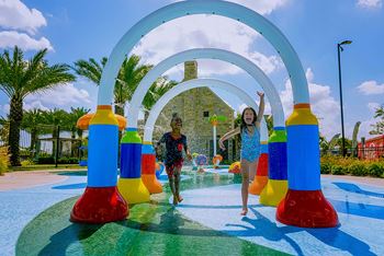 A child is playing in a water play area with colorful inflatable structures.