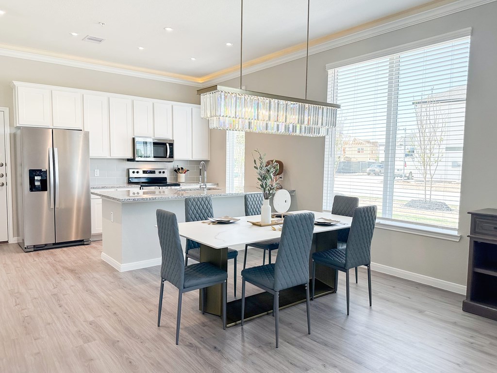 A modern kitchen with a dining table set for four.