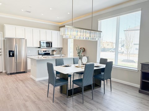 A modern kitchen with a dining table set for four.
