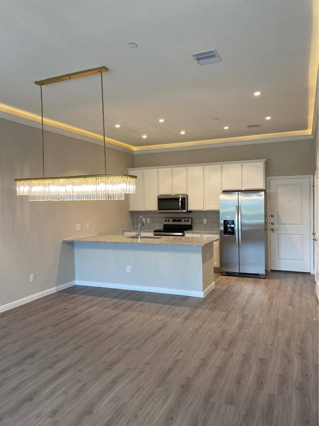 A modern kitchen with a large island and stainless steel appliances.