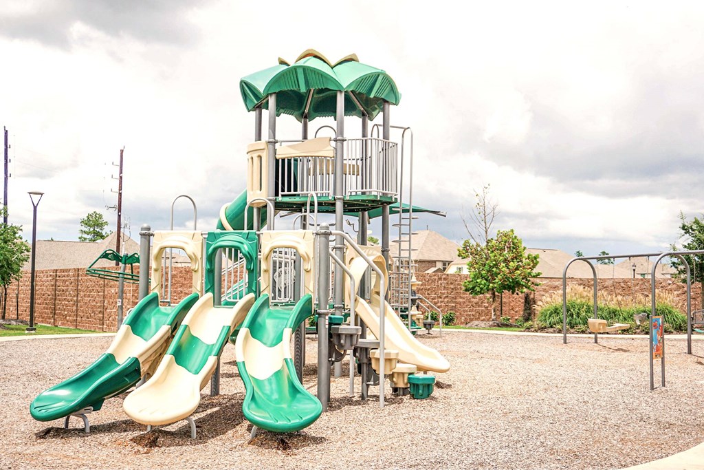 A playground with a green and yellow slide.