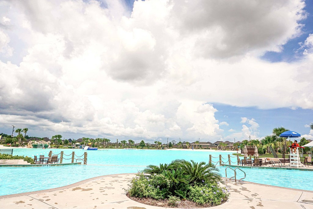 A large swimming pool with a small island in the middle.